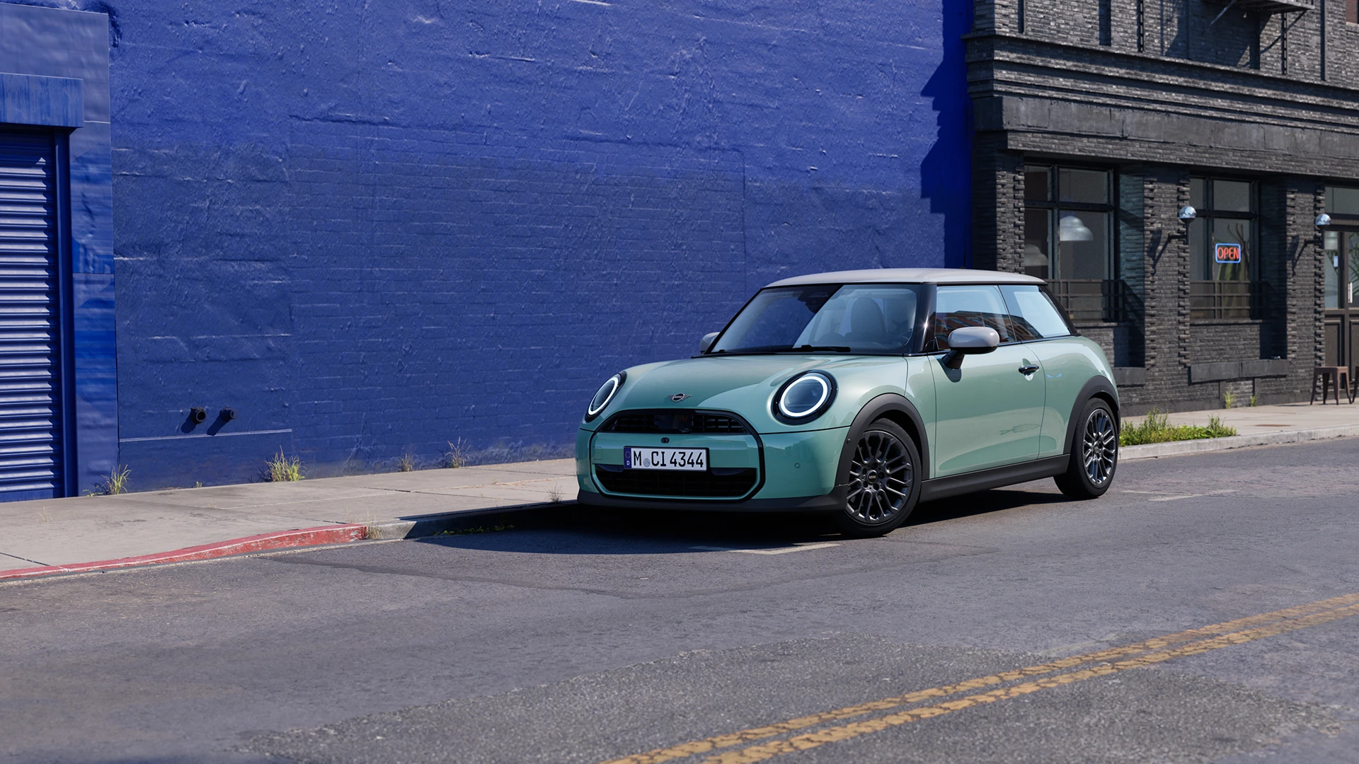MINI Cooper stationné dans une rue urbaine à côté d’un mur bleu.