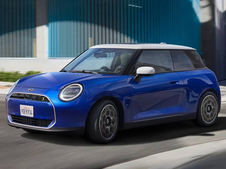 MINI Cooper roulant le long d’une rue urbaine.