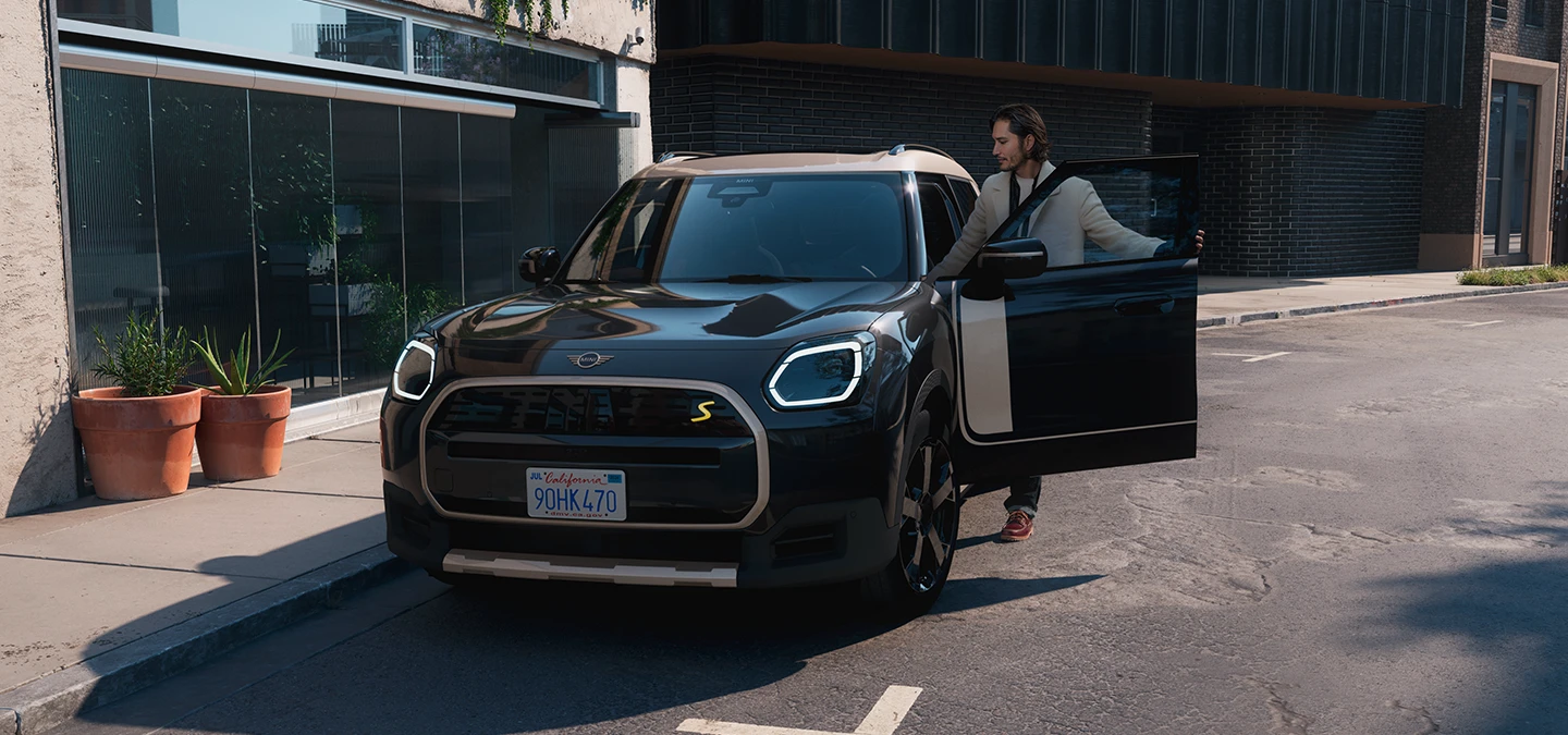 Vue avant du MINI Countryman Electric Midnight Black avec toit Vibrant Silver en ville.