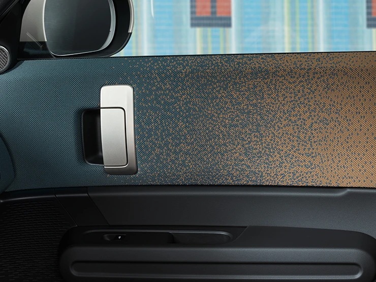 Vue rapprochée du design intérieur du MINI Countryman Electric avec accent sur la porte et le tableau de bord.