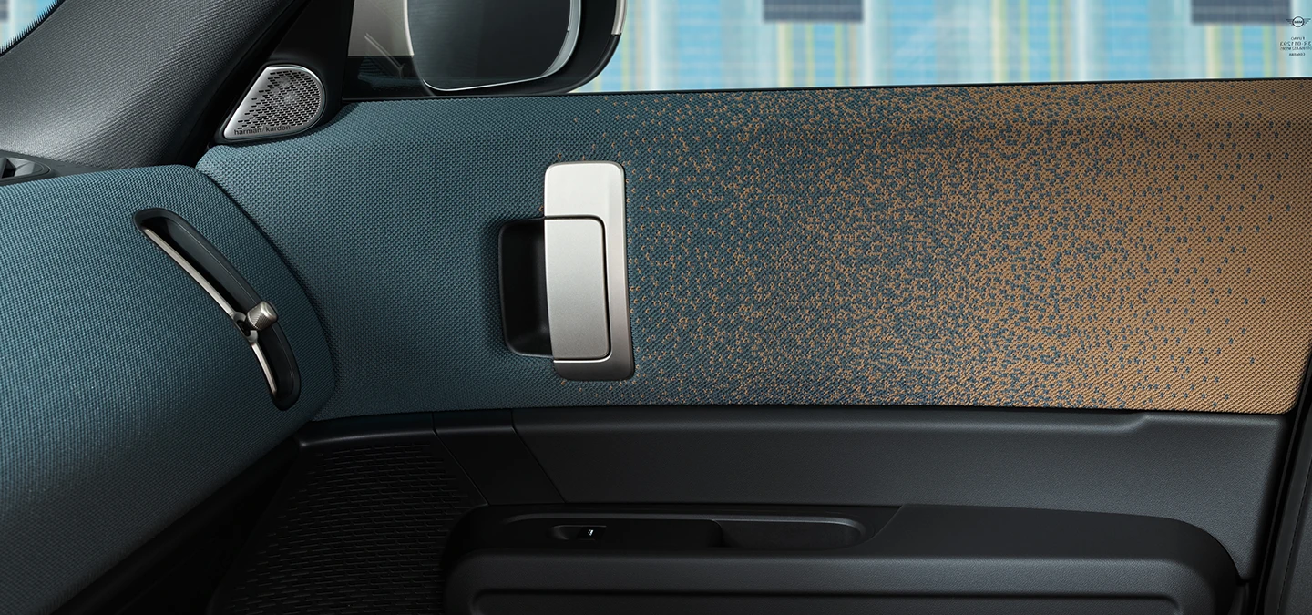 Vue rapprochée du design intérieur du MINI Countryman Electric avec accent sur la porte et le tableau de bord.